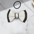 Tuhil Threads Small Royal Micro Satin Classic Bow in a two-tone design with a taupe bottom layer and a cream top layer, neatly tied. Shop Tuhil Threads hair accessories.