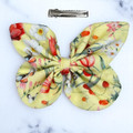 A cheerful Sunny Meadow Floral Medium Cotton Butterfly Bow by Tuhil Threads, measuring approximately 12cm wide by 8cm high. Shop Tuhil Threads hair accessories.