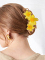 Close-up of a woman's hair with yellow two-tone jelly flower hair clips. Close-up of a woman's hair with yellow two-tone jelly flower hair clips.
