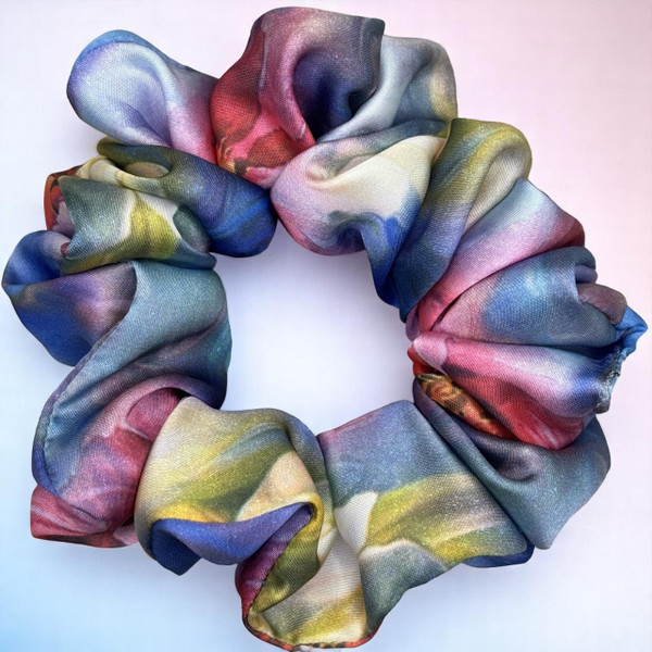 Tuhil Threads Large Vibrant Abstract Silky Satin Scrunchie. Luxurious large silky satin hair tie with a stunning abstract watercolor blend of rich blues, pinks, and purples for an eye-catching, gentle hold. Shop Tuhil Threads hair accessories.