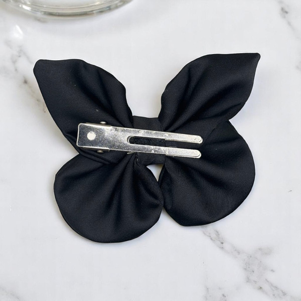 Tuhil Threads small black Royal Micro Satin butterfly bow  showcasing its classic colour and elegant shape. Shop Tuhil Threads hair accessories.