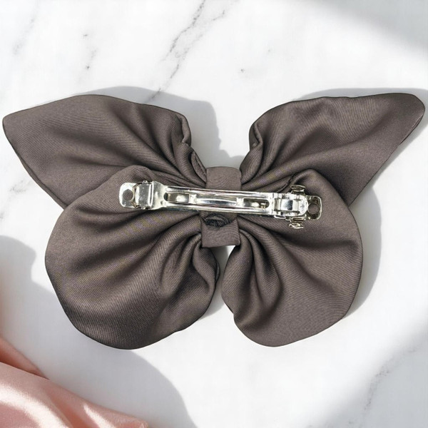 Tuhil Threads medium taupe Royal Micro Satin butterfly bow showcasing its sophisticated neutral colour and elegant shape. Shop Tuhil Threads hair accessories. Tuhil Threads medium taupe Royal Micro Satin butterfly bow showcasing its sophisticated neutral colour and elegant shape. Shop Tuhil Threads hair accessories.