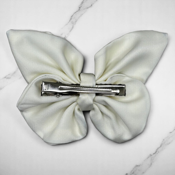Tuhil Threads medium cream Royal Micro Satin butterfly bow (12x8cm) showcasing its soft neutral colour and elegant, graceful shape. Shop Tuhil Threads hair accessories.