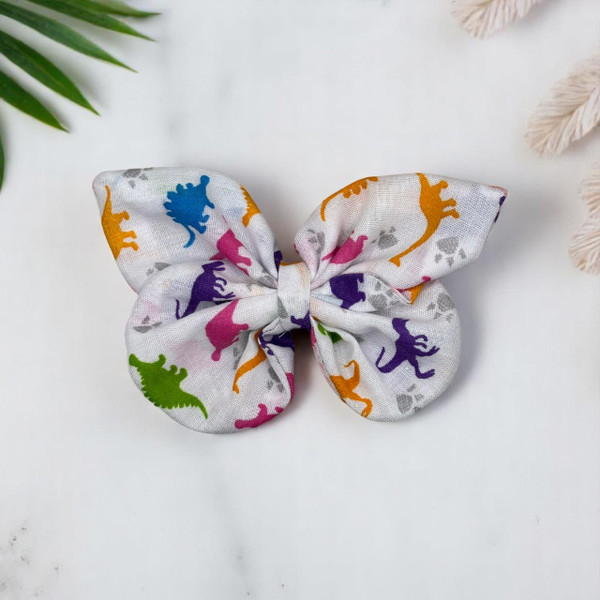 An adorable Dinosaur Print Small Polycotton Butterfly Bow by Tuhil Threads, measuring approximately 10cm wide by 6cm high. Shop Tuhil Threads hair accessories.