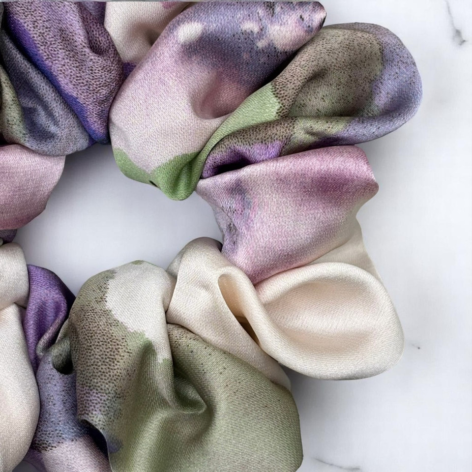 Tuhil Threads Medium Cool Tone Abstract Silky Satin Scrunchie. Smooth and lustrous medium silky satin hair tie featuring a beautiful abstract design in cool purple and green hues for a sophisticated, gentle hold. Shop Tuhil Threads hair accessories.
