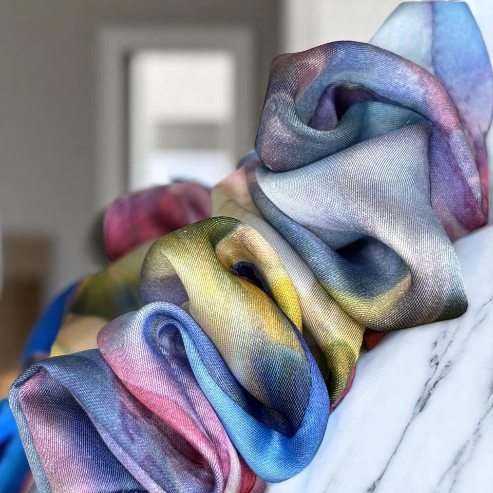 Tuhil Threads Large Vibrant Abstract Silky Satin Scrunchie. Luxurious large silky satin hair tie with a stunning abstract watercolor blend of rich blues, pinks, and purples for an eye-catching, gentle hold. Shop Tuhil Threads hair accessories.