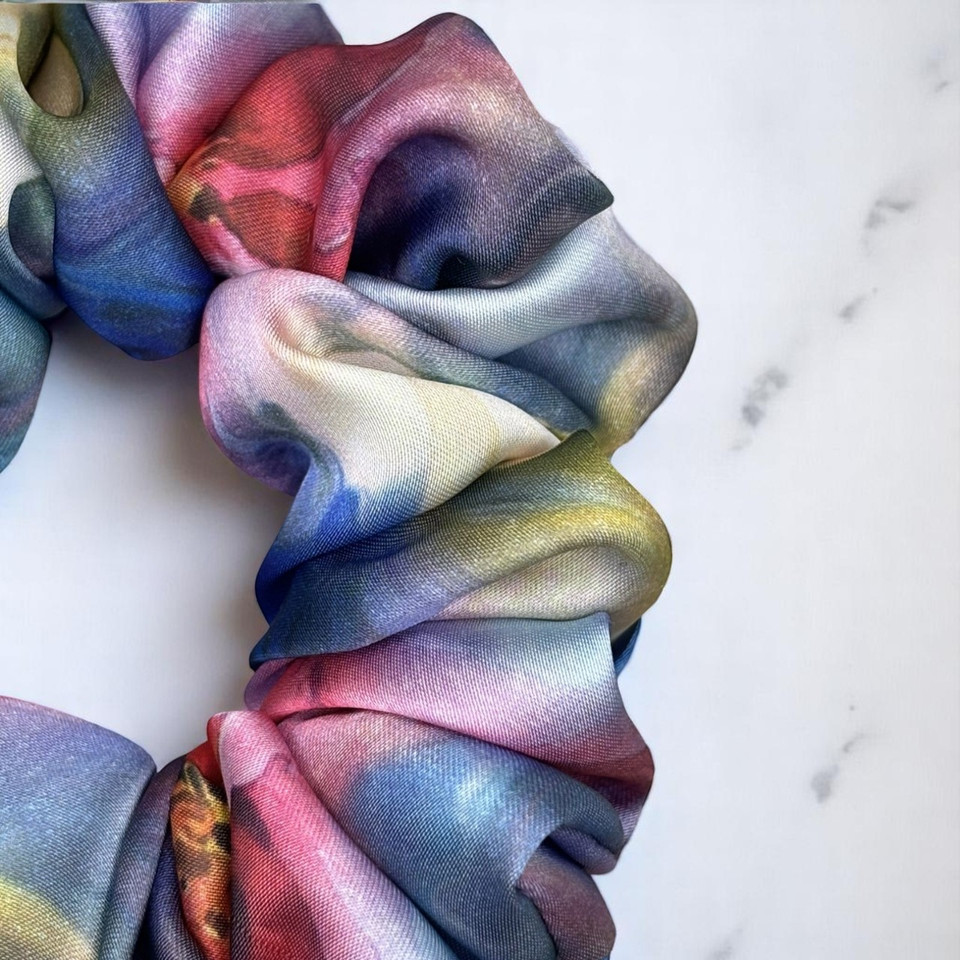 Tuhil Threads Large Vibrant Abstract Silky Satin Scrunchie. Luxurious large silky satin hair tie with a stunning abstract watercolor blend of rich blues, pinks, and purples for an eye-catching, gentle hold. Shop Tuhil Threads hair accessories.