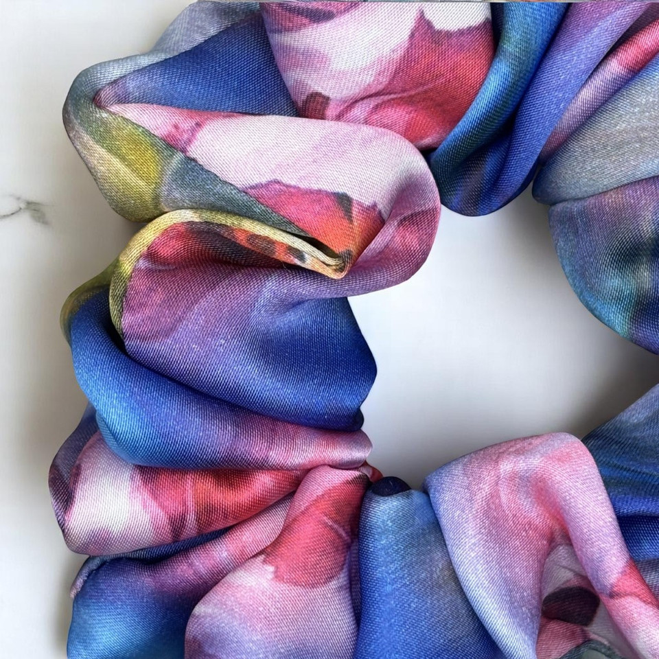 Tuhil Threads Large Vibrant Abstract Silky Satin Scrunchie. Luxurious large silky satin hair tie with a stunning abstract watercolor blend of rich blues, pinks, and purples for an eye-catching, gentle hold. Shop Tuhil Threads hair accessories.