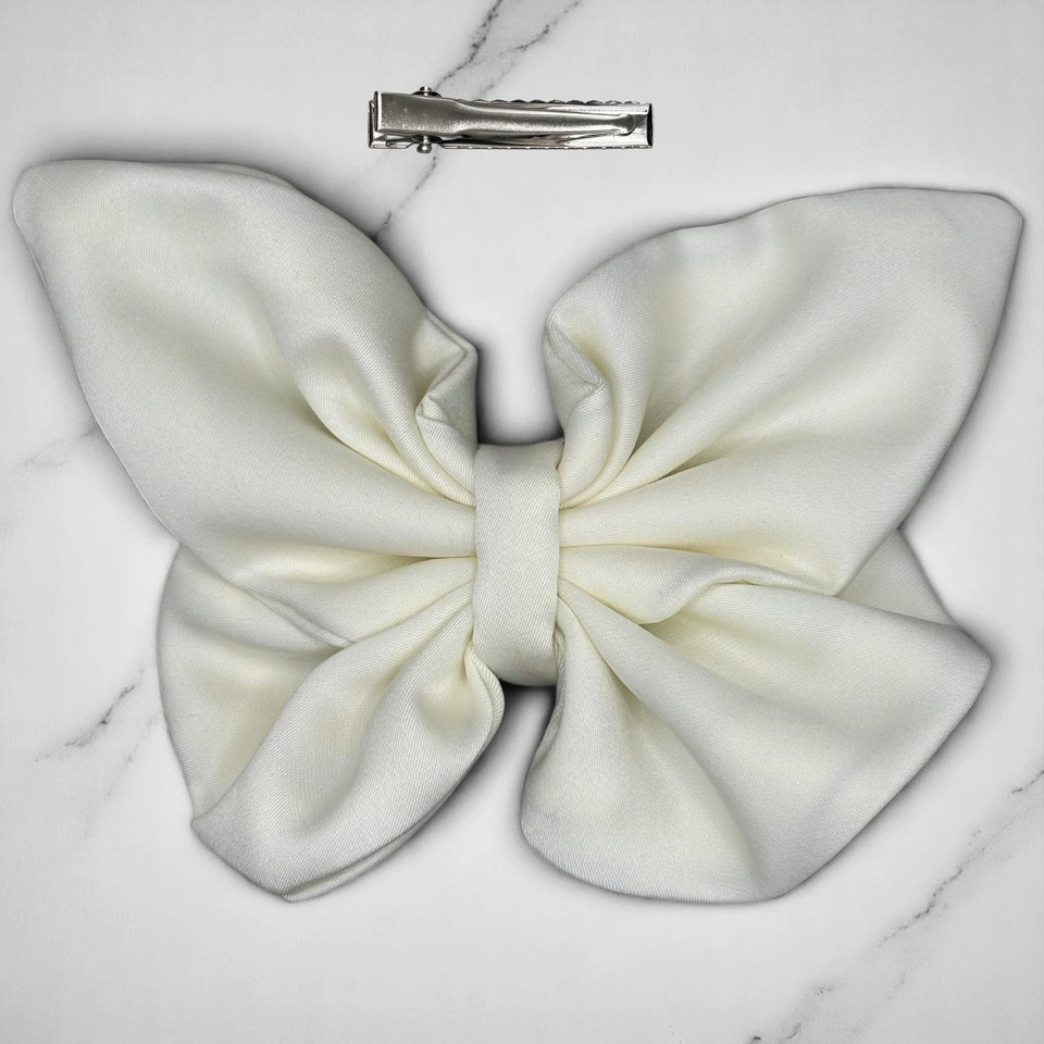 Tuhil Threads medium cream Royal Micro Satin butterfly bow (12x8cm) showcasing its soft neutral colour and elegant, graceful shape. Shop Tuhil Threads hair accessories.
