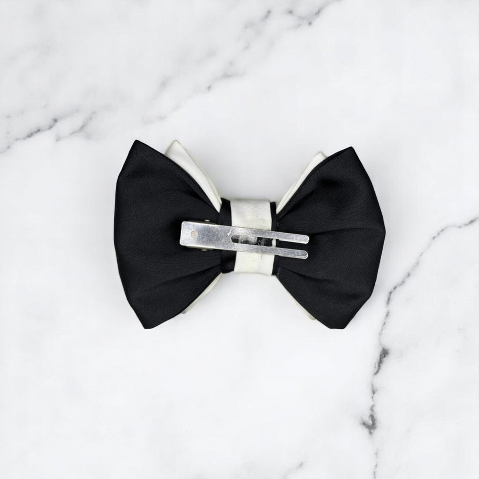 Tuhil Threads Small Royal Micro Satin Classic Bow in a two-tone design with a bold black bottom layer and a cream top layer, neatly tied. Shop Tuhil Threads hair accessories.