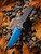 ProTech Mordax - NEXUS textured black handle, Sapphire Blue PVD Magnacut blade, abalone button, black hardware, DLC deep carry clip, plain edge. MX106-SB NEXUS