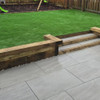 Sleepers used as a step to a raised lawn in garden.