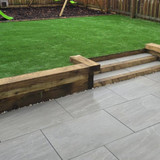 Sleepers used as a step to a raised lawn in garden.