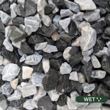 Close up photograph of Black Ice. When wet, stones transforms into a striking jet-black obsidian look with bright white accents.