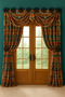 This southwestern window treatment features bold patterned drapery panels hung from handcrafted star medallions, creating a striking design without the use of rods. The rich teal walls complement the earthy tones of the fabric and natural wood doors, enhancing the room’s rustic charm.
