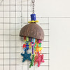 Metade de um coco, e formas coloridas e fofas, como chupetas e estrelas penduradas nele. Um brinquedo tão bonito para o seu pássaro brincar!