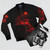 A red bomber jacket with a dark animal silhouette design against a nature backdrop [focus keyword] - Flat lay