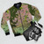 A nature landscape-inspired bomber jacket featuring mountain, lake, and river scenery in shades of pink and blue. - Flat lay