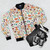 Watercolor floral and fungus pattern on a women's bomber jacket - Flat lay