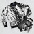 Black and white paint splatter bomber jacket with distressed, abstract design - Flat lay