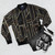 A black and gold geometric abstract bomber jacket - Flat lay