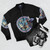 A blue bomber jacket featuring the heart insignia from the Kingdom Hearts video game series, with characters like Aqua, Ventus, and Terra. - Flat lay