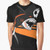 A graphic t-shirt design featuring a shark playing soccer on a black and orange background