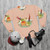 Cinnamon conure parrot on a cozy sweatshirt with fluffy pancake prints - flat lay