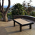 R&R Outdoor South Beach Pool Table with sand coloured felt set on a backyard patio with trees and a mountain in the background.