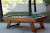Legacy Barren Outdoor Pool Table with traditional green pool table felt, pool balls and pool cues set on a backyard patio.