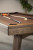 Close up of Luxx pool table corner with a cue ball and cue sticks on a brown felt table.