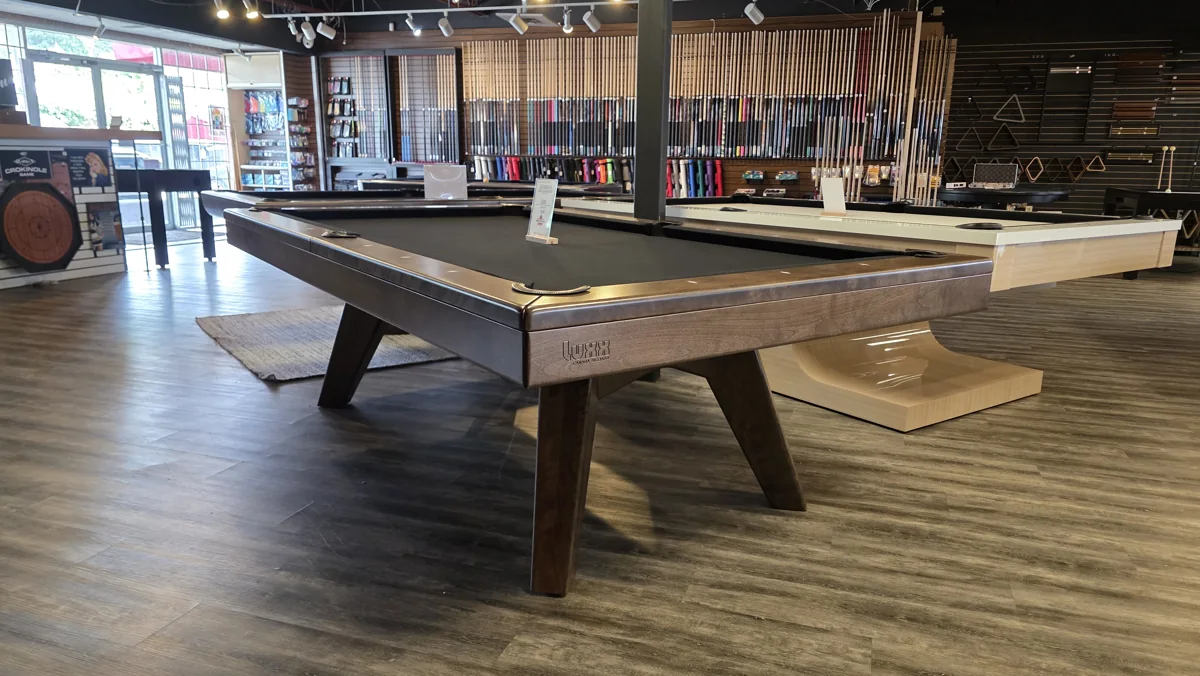 Luxx and contemporary pool tables with cue displays on the Home Billiards showroom floor