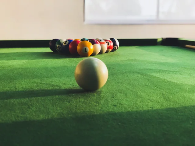Racked balls on a green pool table.