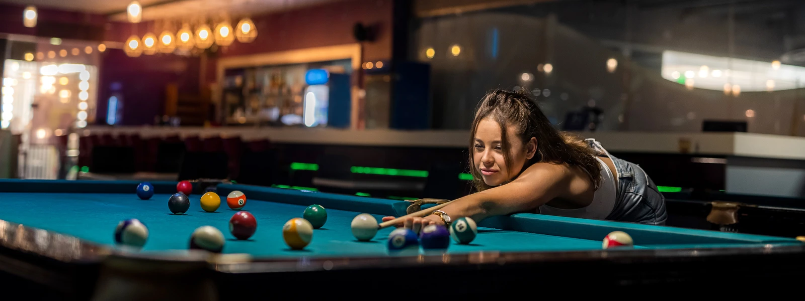 A player lining up a shot in a pool hall