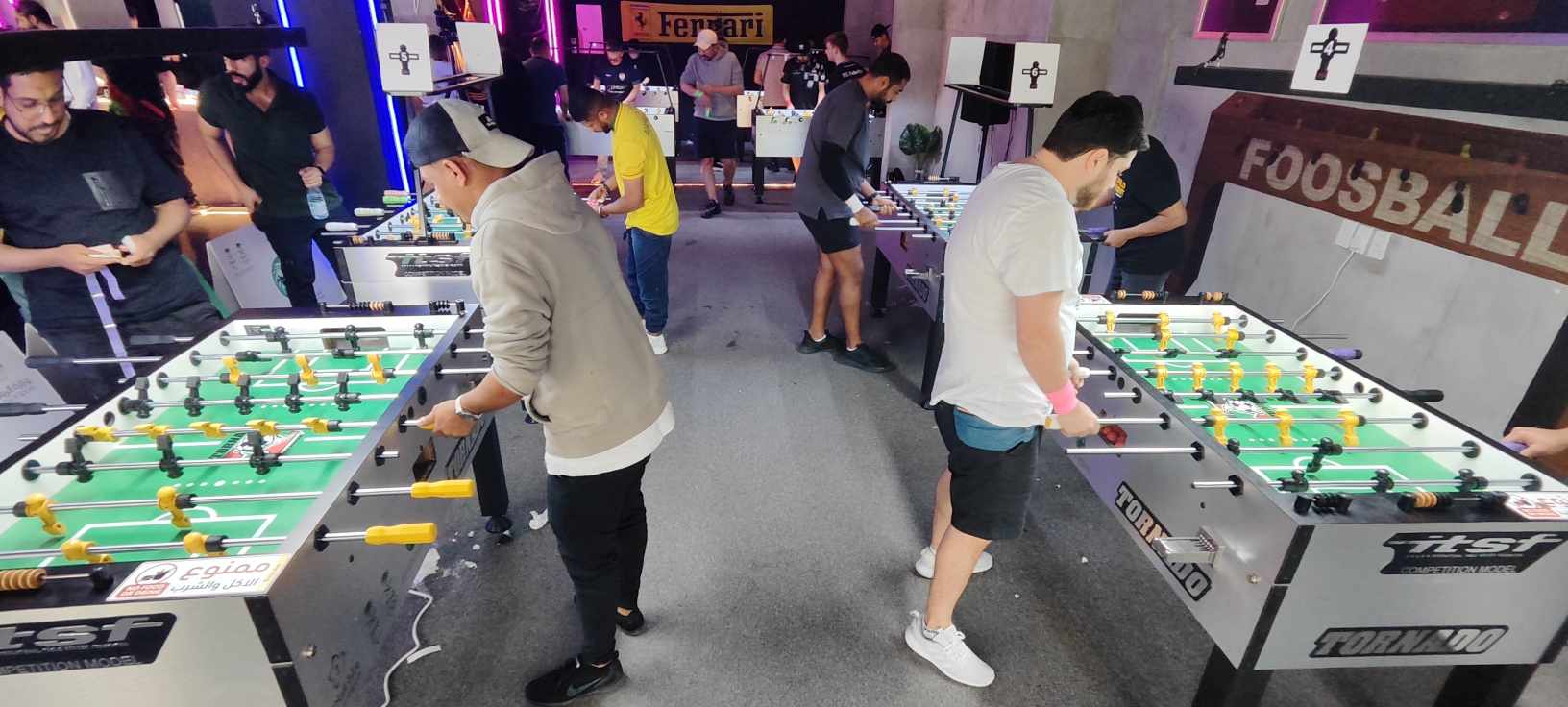 Players competing on clearly branded Tornado foosball tables at a tournament