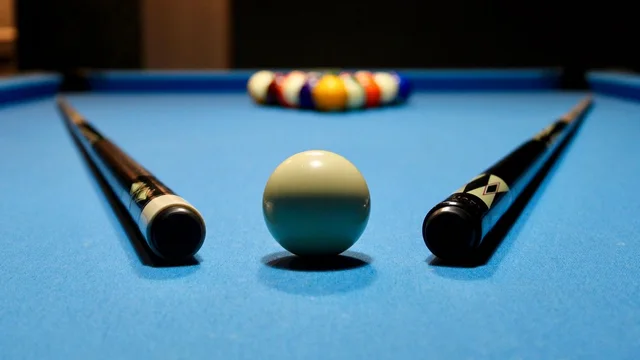 Pool cues arranged on a billiards table.