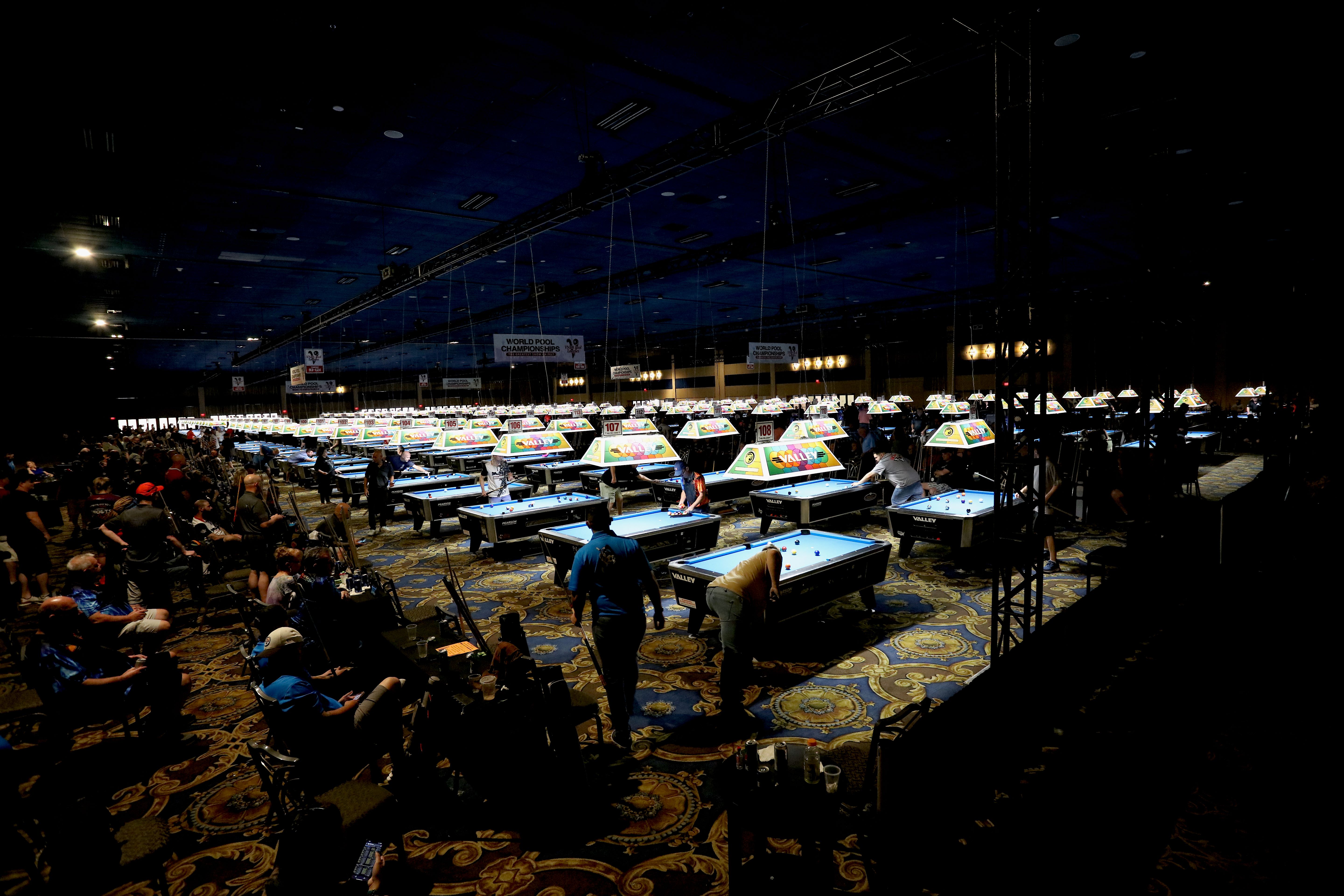 Players competing on rows of Valley pool tables in a VNEA tournament room