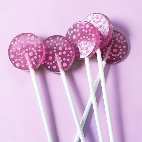 Five light purple, round, smooth, glossy hard candy Berries and Cream Lollipops with extra long white paper lollipop sticks, in a row, each with pink/purple spiral confetti flavor dots on a light purple/pink background.