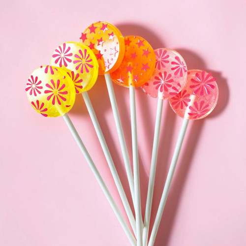 Six bright colored, round, smooth, glossy hard candy Lollipops with extra long white paper lollipop sticks, each with coral pink color flower pattern on a light pink background.