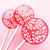 Three round, glossy coral pink color hard candy lollipops on top of extra long white paper lollipop sticks. Shown upright in a row with white flower petal designs. All on a light pink background.