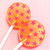 Two bright orange, round, smooth, glossy hard candy Tropical Punch Lollipops with extra long white paper lollipop sticks, each with coral pink color flavor star pattern on a light coral pink background.