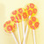 Five bright yellow, round, glossy hard candy Banana Cream Lollipops with extra long white paper lollipop sticks, each with coral pink color pinwheel flavor flowers on a light butter yellow color background.