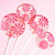 Four light pink, round, glossy Strawberry Banana hard candy Lollipops with extra long white paper lollipop sticks and coral pink color pinwheel flavor flowers, on a light pink background showing very pink-on-pink flower bunch bouquet.