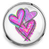 SnapAccents snap jewelry charm featuring three vibrant, hand-drawn pink and purple hearts with colorful accents, set in a shiny silver-tone round frame, perfect for customizable snap bracelets, necklaces, and accessories.