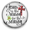 Round SnapAccents snap jewelry charm with "Jesus is the reason for the season" text, featuring a red and black buffalo plaid cross and green holly leaves, set against a festive red background with snowflake patterns.