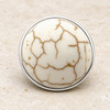 round snap jewelry charm with smooth cream surface and brown veining resembling natural howlite stone in a silver-tone setting