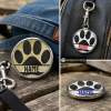 SnapAccents customizable snap jewelry featuring black paw print design on white and gold backgrounds with bold "NAME" text, perfect for pet lovers, interchangeable snap charm accessories, stylish and personalized gift idea.