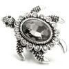 Gray sea turtle snap jewelry charm with a large faceted dark gray rhinestone center and smaller clear rhinestones around the edges