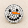 round snap jewelry charm designed as a snowman face with clear rhinestones, black rhinestone eyes and mouth, and an orange carrot-shaped nose