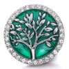 Round SnapAccents snap jewelry charm with silver tree design on emerald green background, surrounded by clear rhinestone border, decorative interchangeable accessory for bracelets and necklaces.